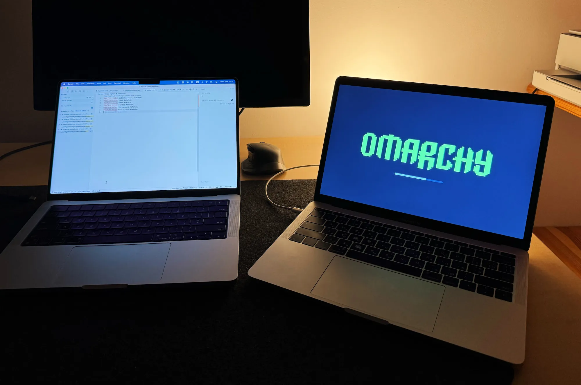 Two MacBooks, one running macOS and another running Omarchy
